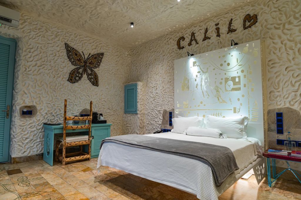 Helles Schlafzimmer mit dekorativem Wandkunstwerk und gemütlichem Bett.