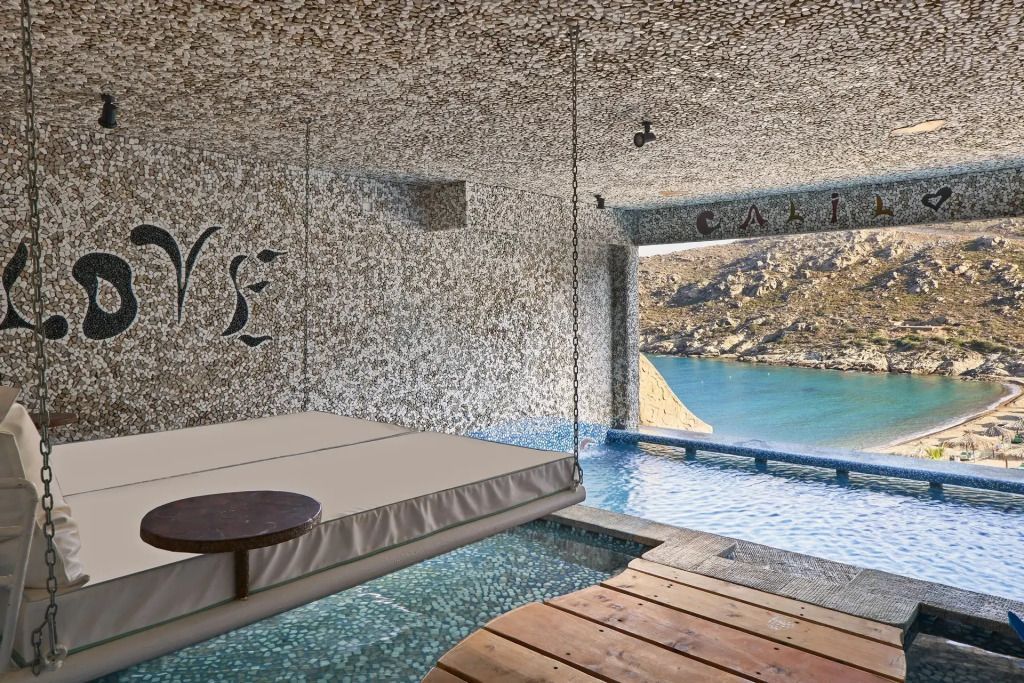 Luxus-Indoor-Pool mit Blick auf die Küstenlandschaft und dekorative Wandverzierung.