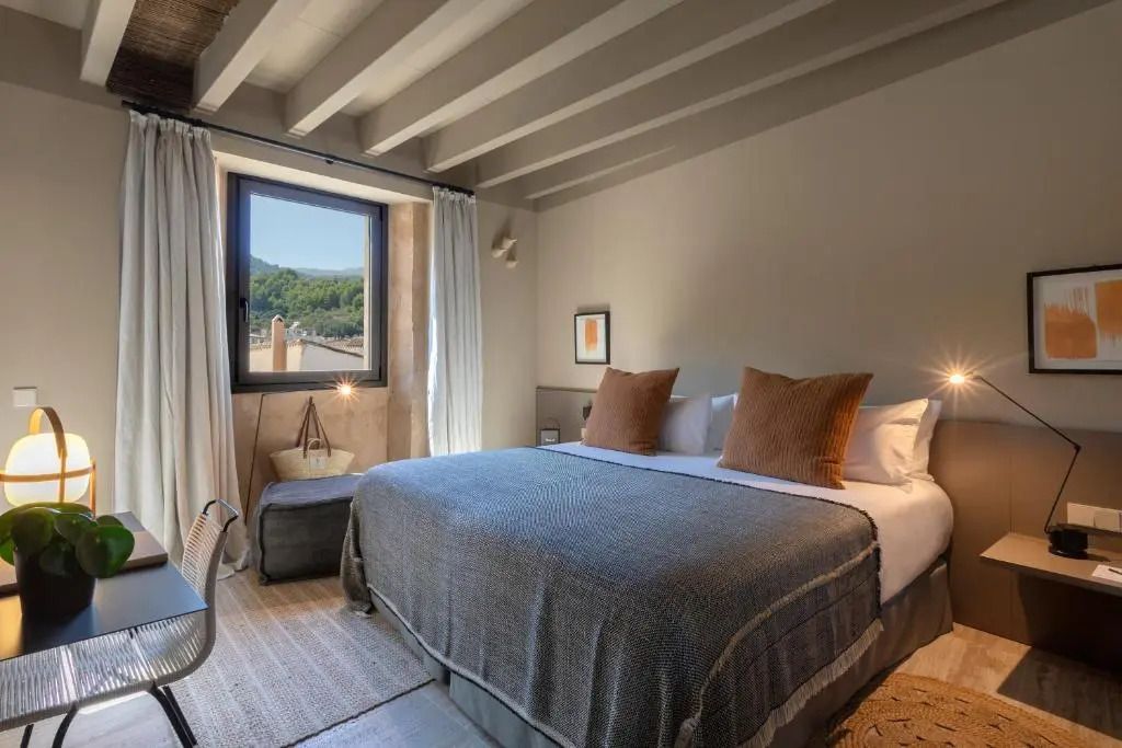 Elegantes Deluxe Doppelzimmer mit großem Bett und Blick auf die Landschaft