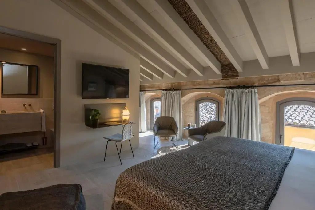 Doppelzimmer mit Holzbalkendecke und modernen Annehmlichkeiten.