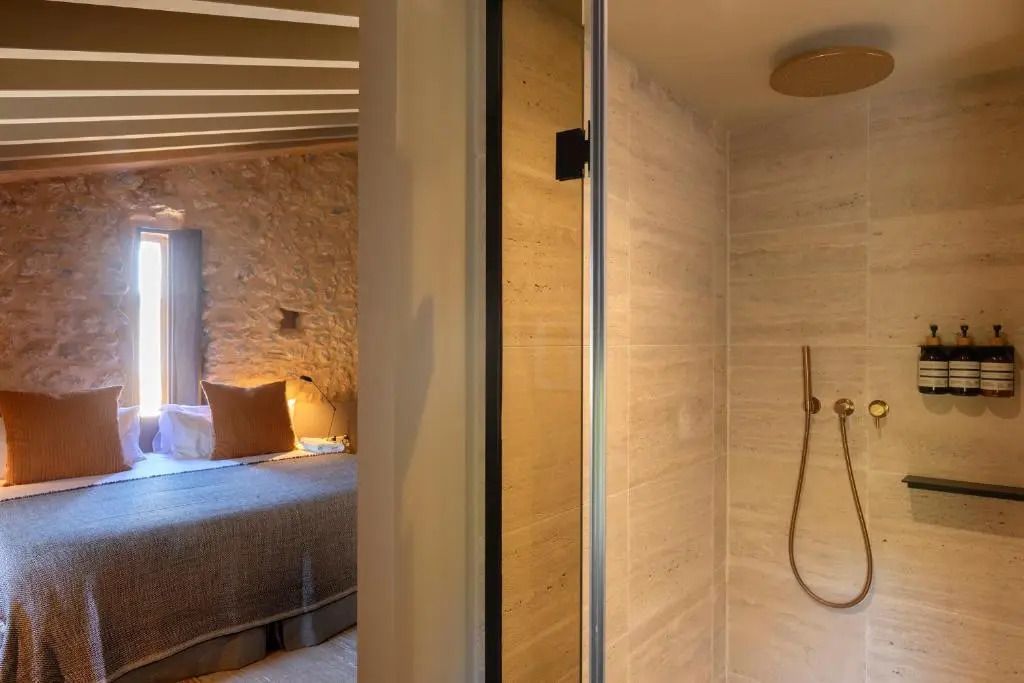 Elegantes Standard Doppelzimmer mit Doppelbett und moderner Dusche in warmen Farbtönen