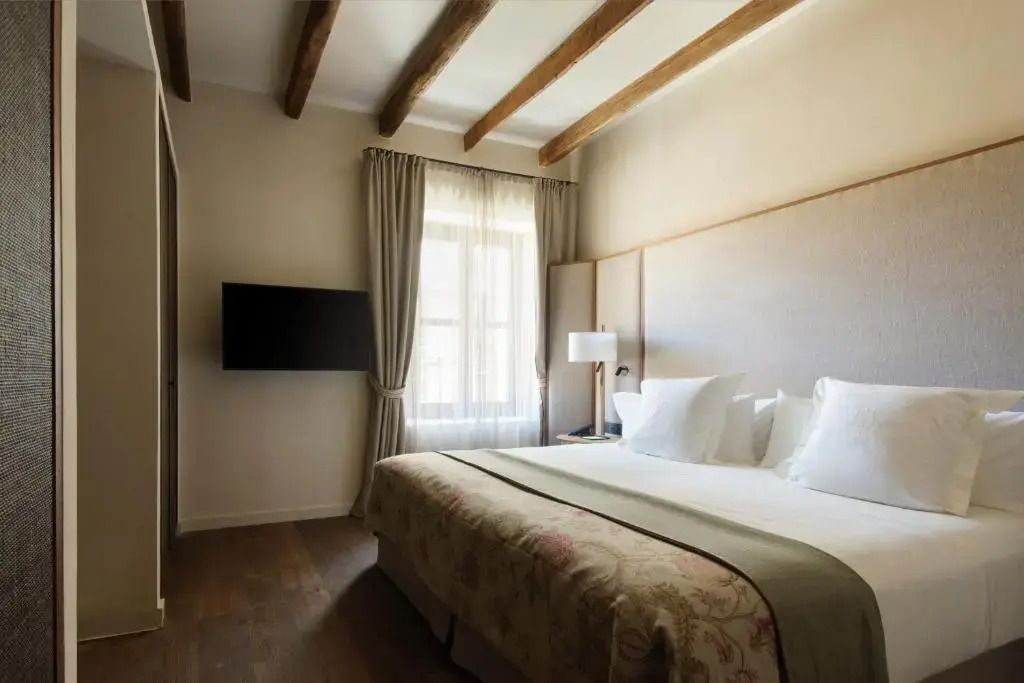 Gemütliches Schlafzimmer mit Holzbalken und großem Fenster