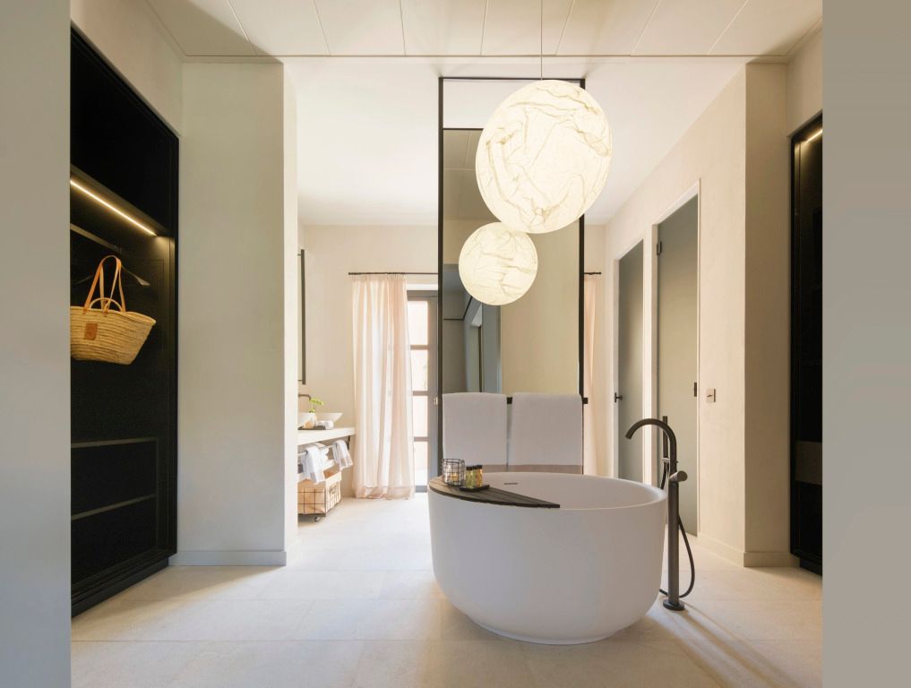 Modernes Badezimmer mit freistehender Badewanne und großen hängenden Leuchten.