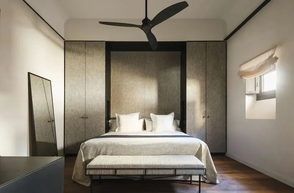 Modernes Doppelzimmer mit einem eleganten Bett und einem stilvollen Ventilator