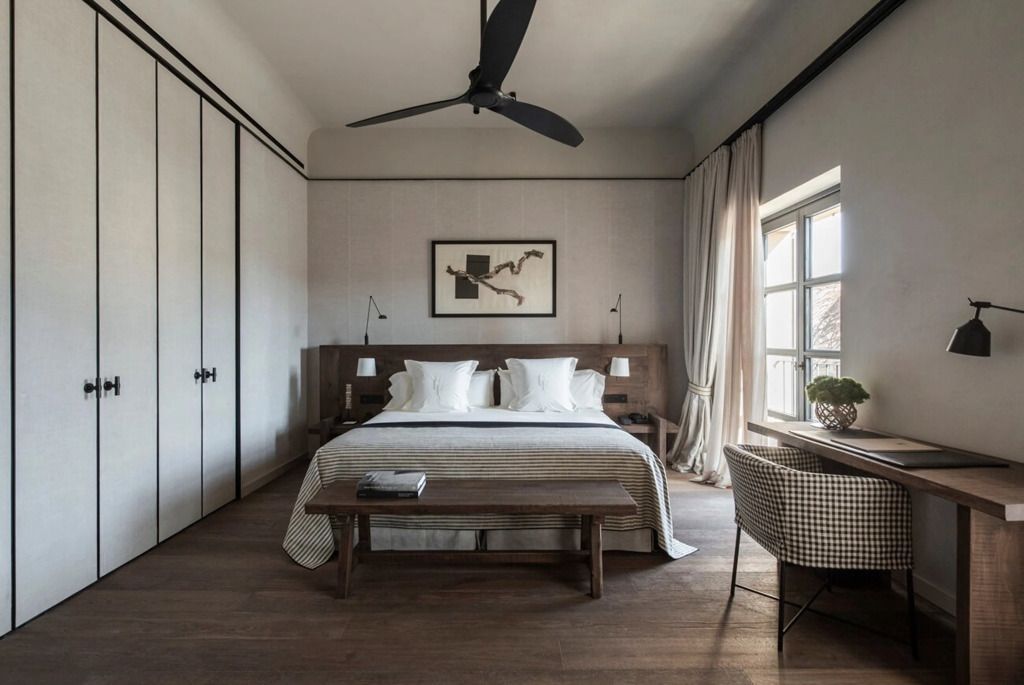 Elegantes Schlafzimmer in der Junior Suite mit großen Fenstern und schlichter Einrichtung