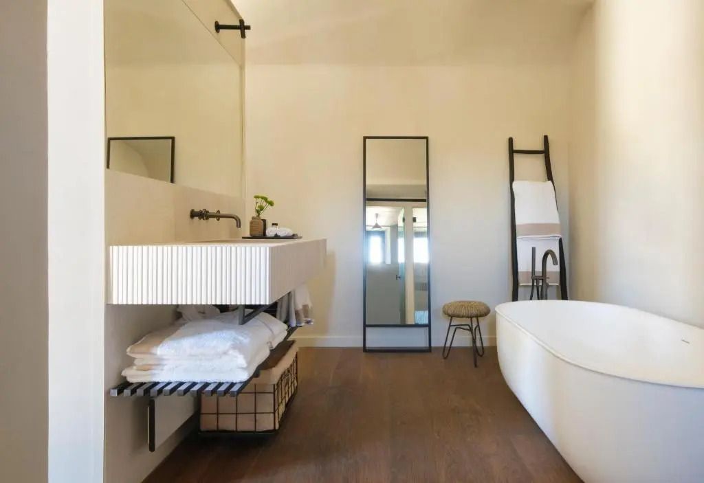 Modernes Badezimmer mit freistehender Badewanne und elegantem Spiegel