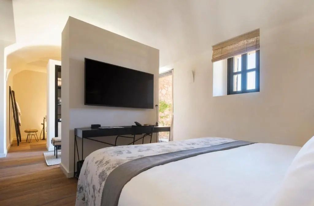 Fernseher auf Wandhalterung im modernen Schlafzimmer mit großem Bett