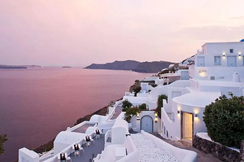 Panoramablick auf weiße Gebäude und Meer bei Sonnenuntergang in Santorini