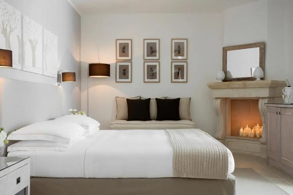 Elegantes Schlafzimmer mit Doppelbett und Kamin in beruhigenden Farbtönen