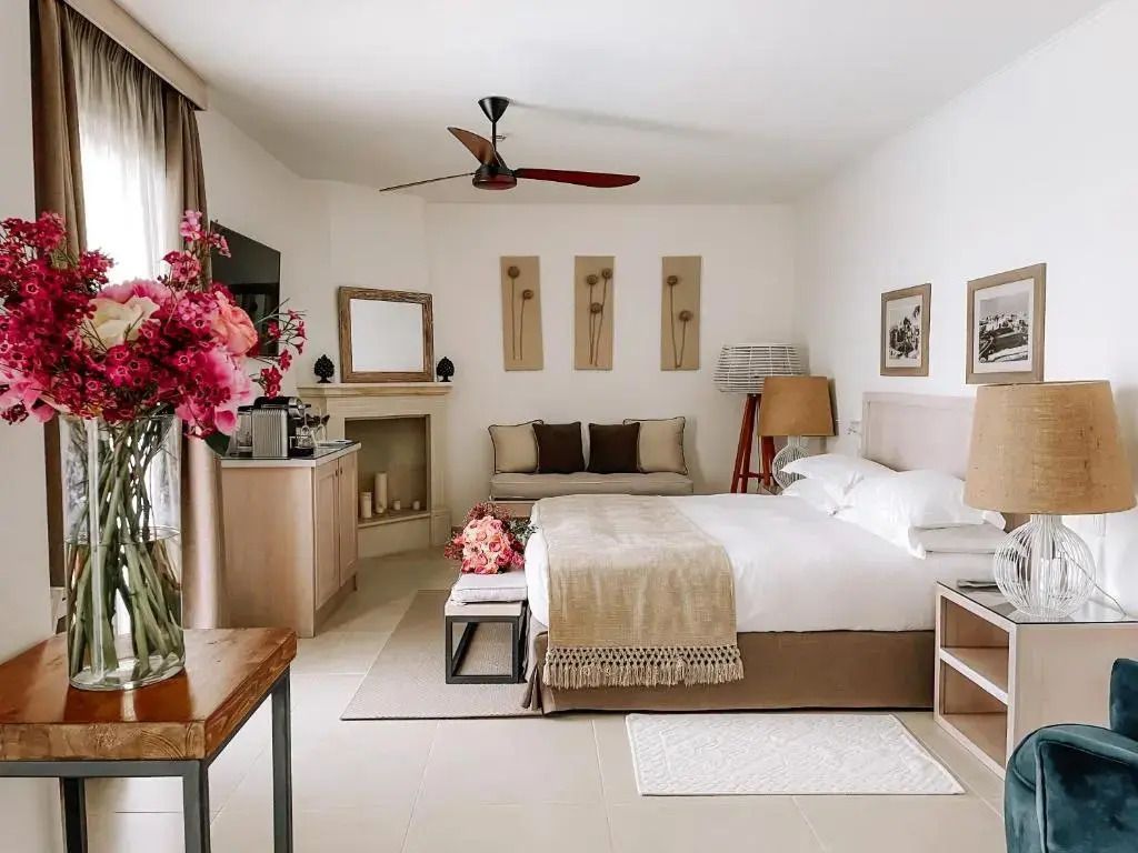 Helles und geschmackvolles Zimmer mit Doppelbett, Sitzgelegenheit und Dekoration