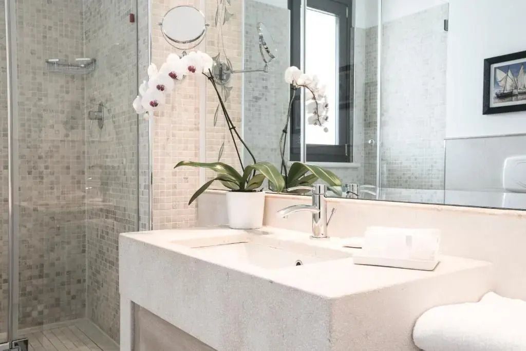 Modernes Badezimmer mit eleganter Waschbeckenfläche und Orchidee