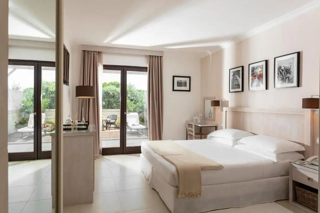 Helles Doppelzimmer mit großem Bett und Balkonzugang, natürlicher Lichteinfall