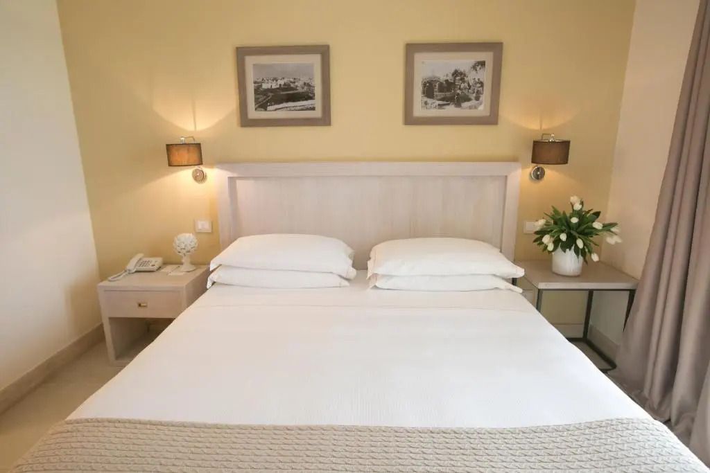 Gemütliches Schlafzimmer mit großem Doppelbett und dekorativen Bildern an der Wand
