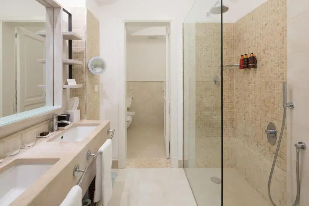 Badezimmer der Suite mit moderner Dusche und Doppelwaschbecken