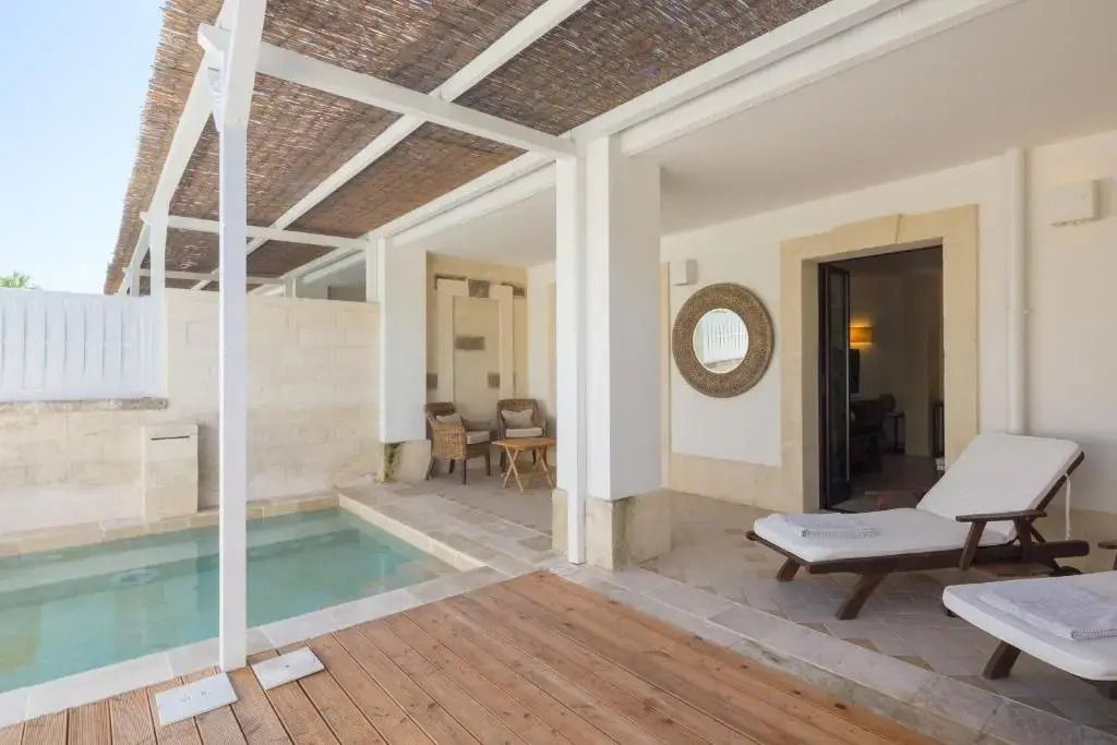 Patio mit kleinem Pool und stilvollen Liegen vor der Suite