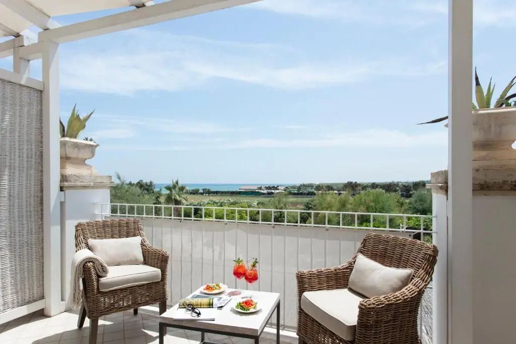 Balkon mit Sitzbereich und Meerblick bei Sonnenschein