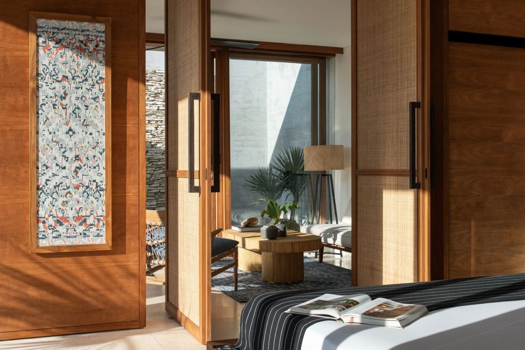 Elegant eingerichtete Suite mit schlichten Holzmöbeln und Zugang zu einem privaten Bereich