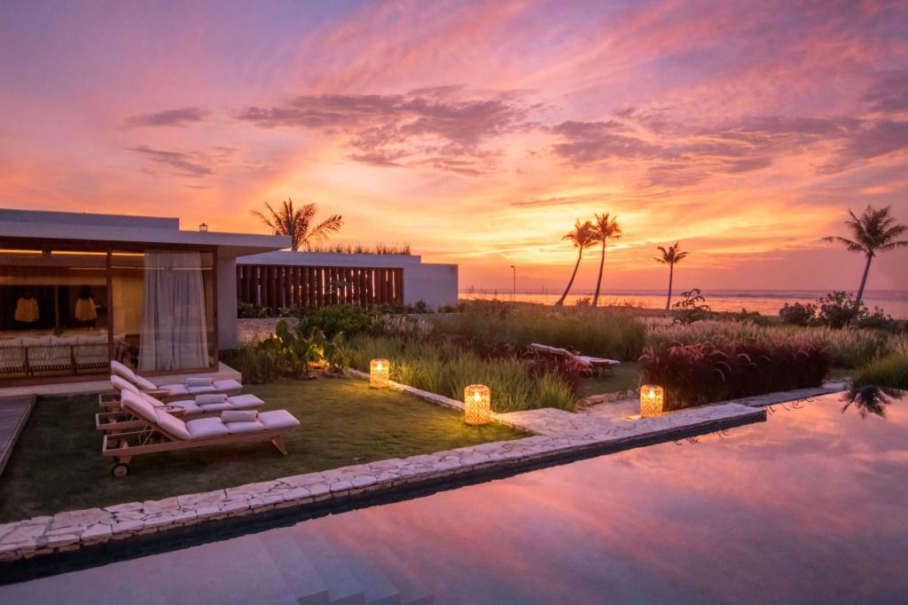 Villa in tropischer Landschaft bei Sonnenuntergang am Strand
