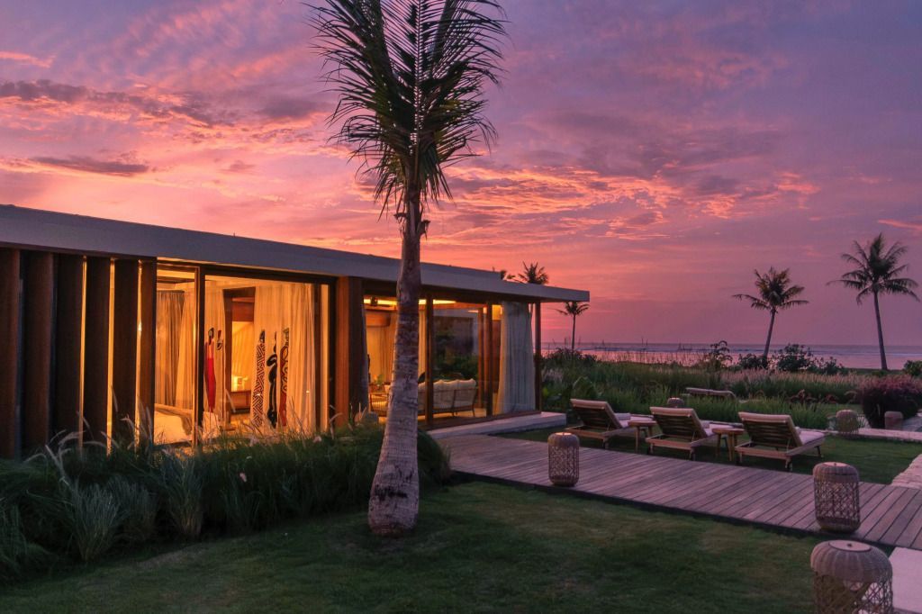 Villa bei Sonnenuntergang mit Holzterrasse und Garten