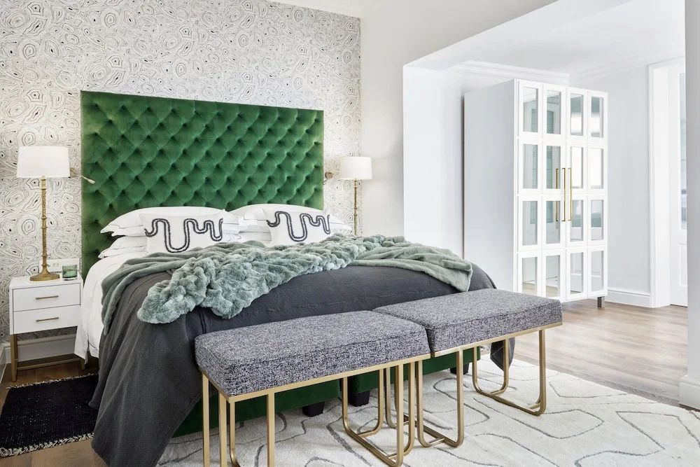 Geräumiges Zimmer mit grüner Kopfteil und eleganter Dekoration.