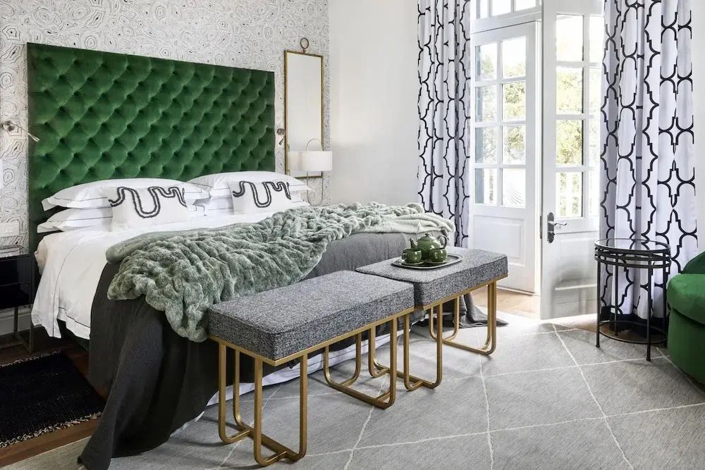 Luxuriöses Schlafzimmer mit grün gepolstertem Kopfteil und eleganter Einrichtung