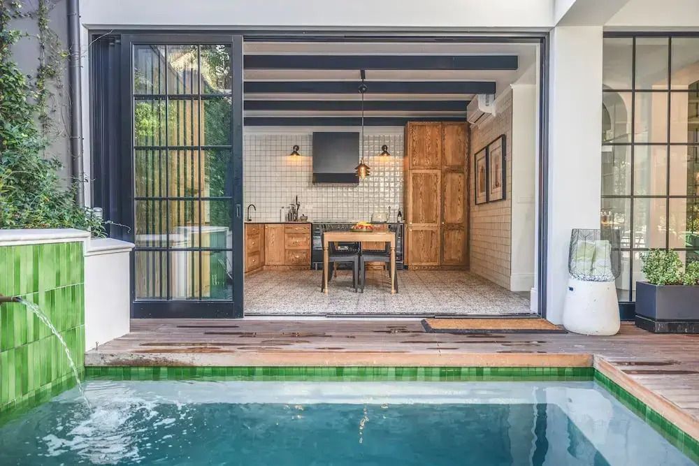 Offene Küche mit Esstisch und Blick auf einen kleinen Pool
