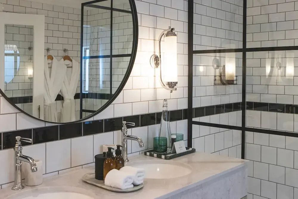 Doppelte Waschbecken mit stilvollen Armaturen und Spiegel im Badezimmer