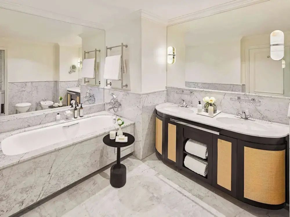 Luxuriöses Badezimmer mit Marmorelementen und Doppelwaschbecken.
