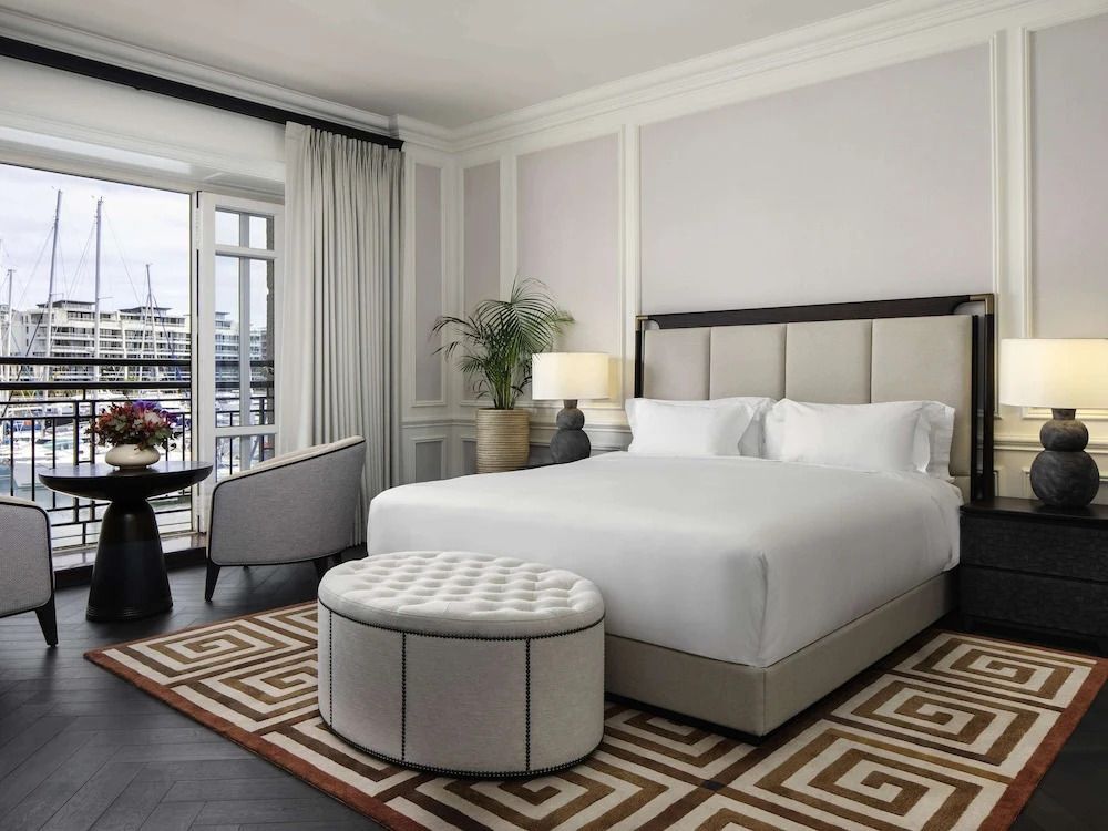 Helles Zimmer mit großem Bett, Sitzecke und Balkonzugang.