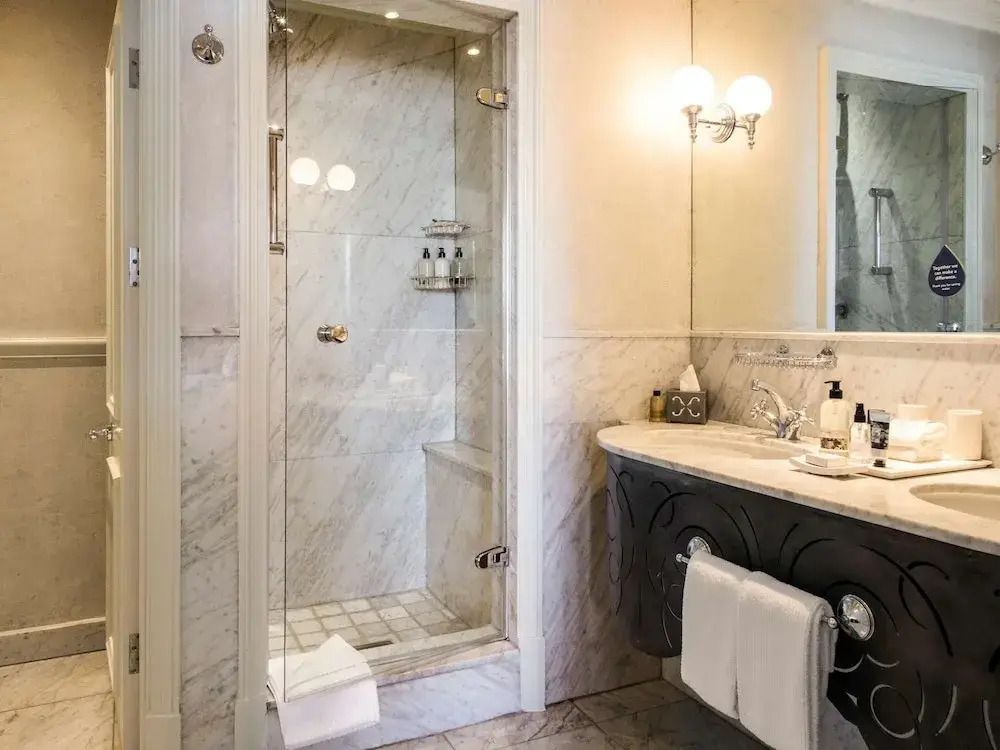 Luxuriöses Badezimmer mit Marmorelementen und großer Dusche