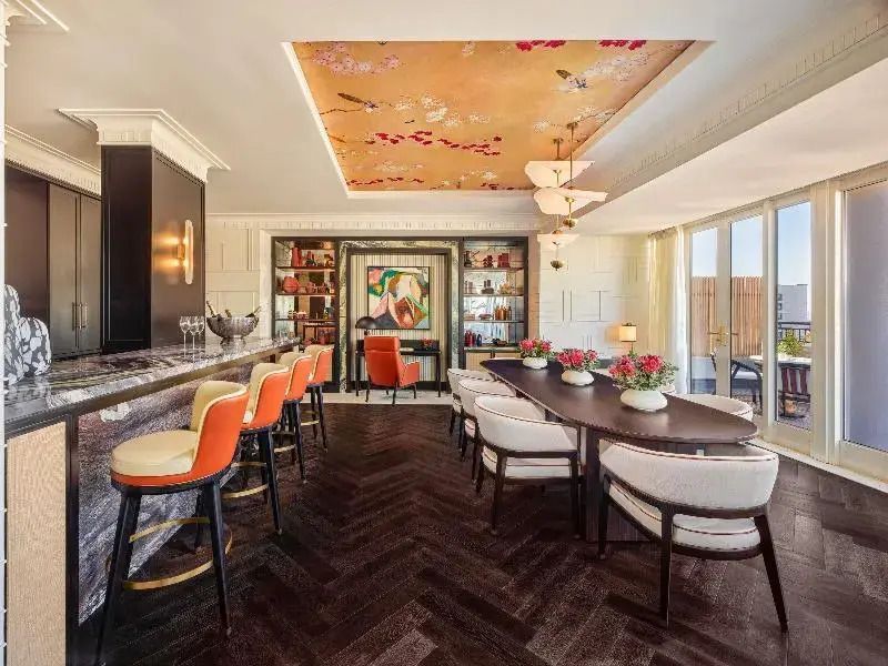 Elegante Bar und Essbereich mit kunstvoller Decke und stilvollen Möbeln