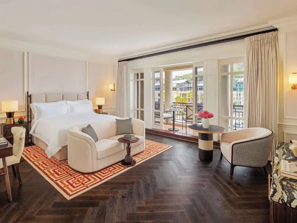 Großzügiges Zimmer mit Sofa, Doppelbett und Zugang zu einem Balkon.