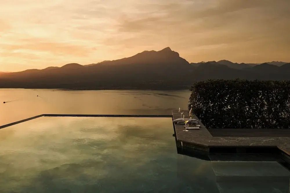 Infinity-Pool mit atemberaubendem Blick auf den See bei Sonnenuntergang