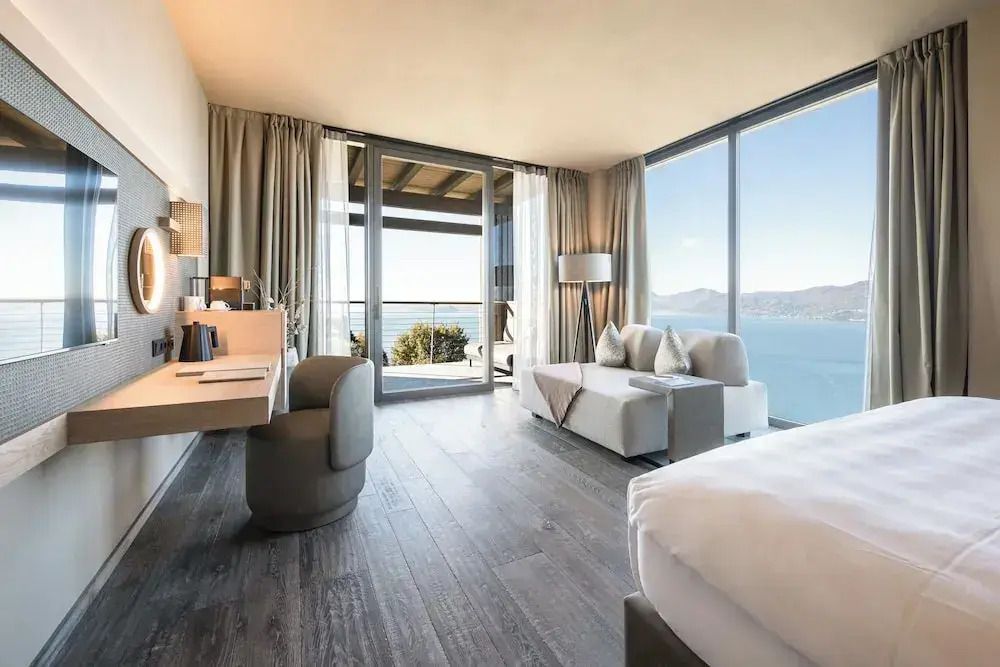 Deluxe Suite mit modernem Interieur und Seeblick durch große Fenster