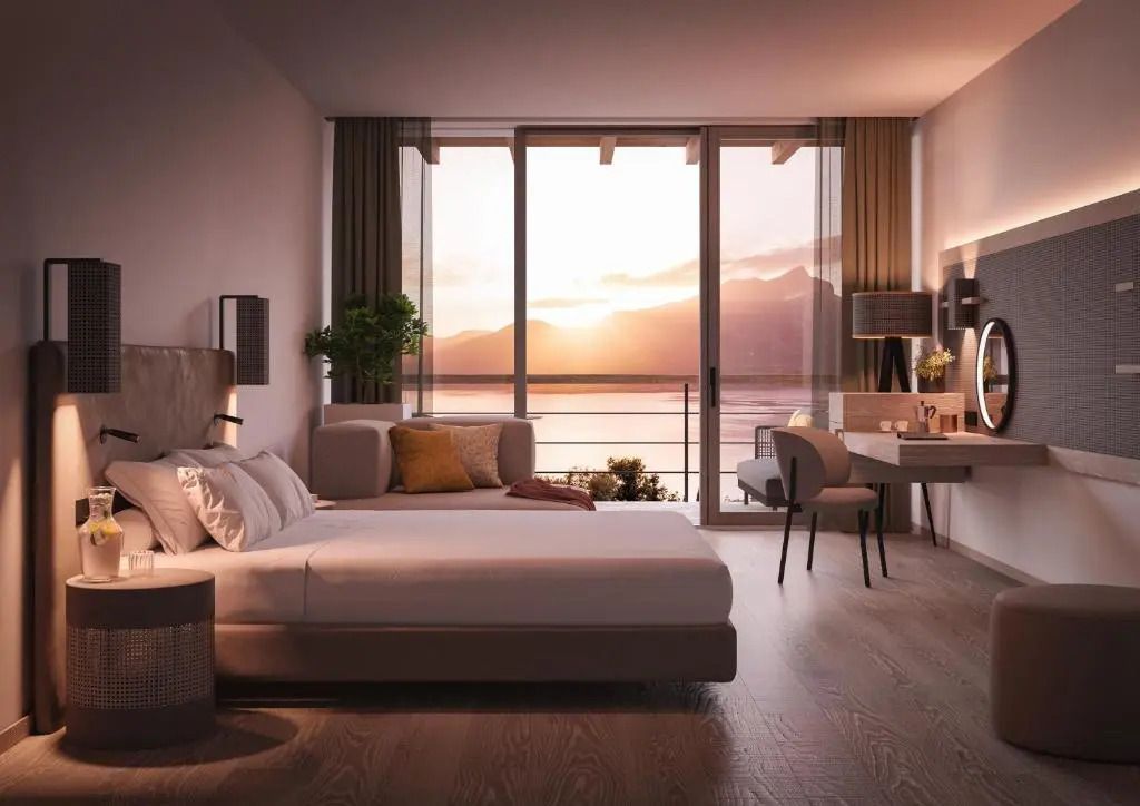 Junior-Suite mit Bett und Schreibtisch, Blick auf den Sonnenuntergang am Meer