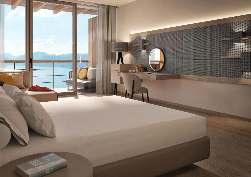 Schlafzimmer der Junior-Suite mit Balkonblick auf die Berge und den See