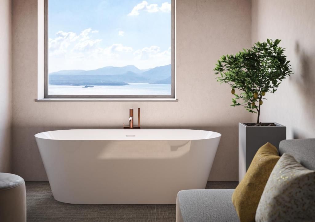 Freistehende Badewanne mit Fensterausblick auf Berge