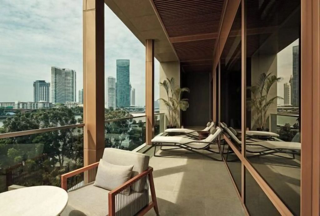 Balkon mit Liegestühlen und Blick auf die Skyline von Bangkok.