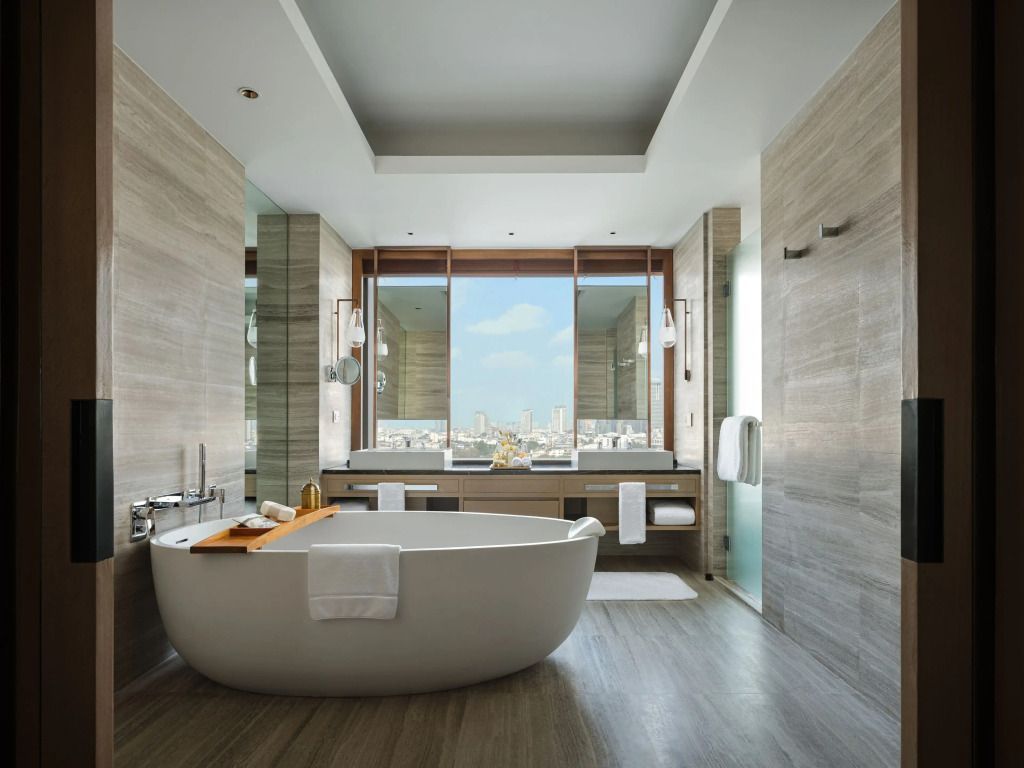 Luxuriöses Badezimmer mit freistehender Badewanne und Blick auf die Stadt.