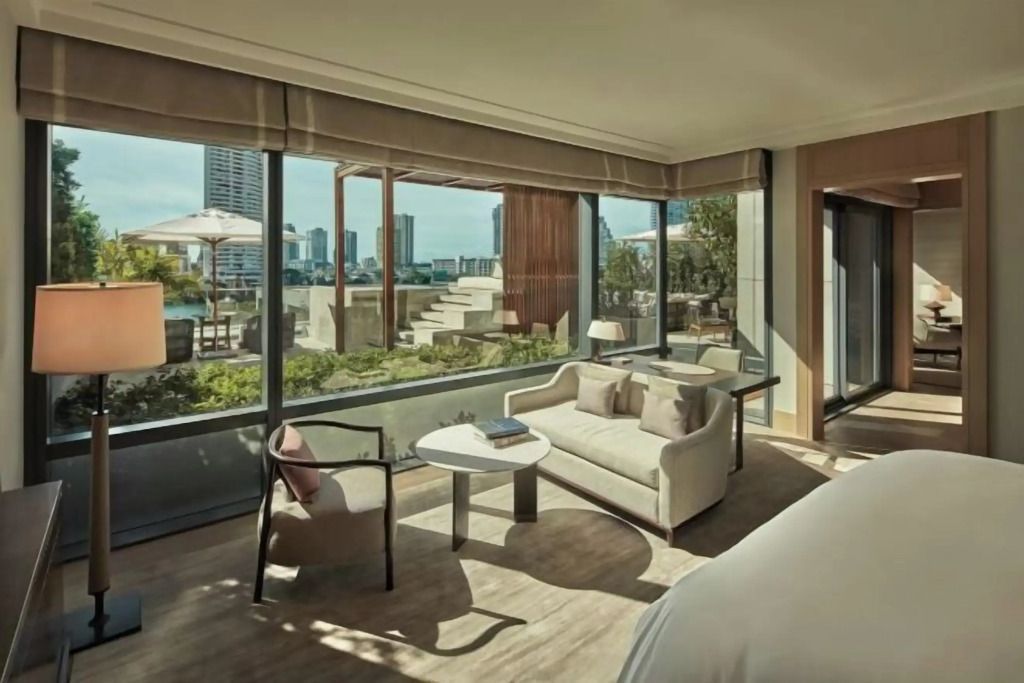 Heller Zimmerbereich mit Sitzgelegenheit, Blick auf die Terrasse und Skyline.