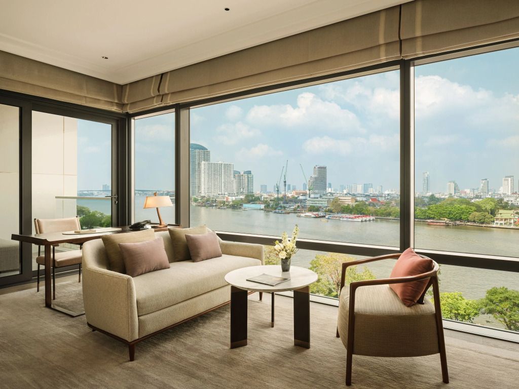 Zimmeransicht mit großer Fensterfront und Flussblick.