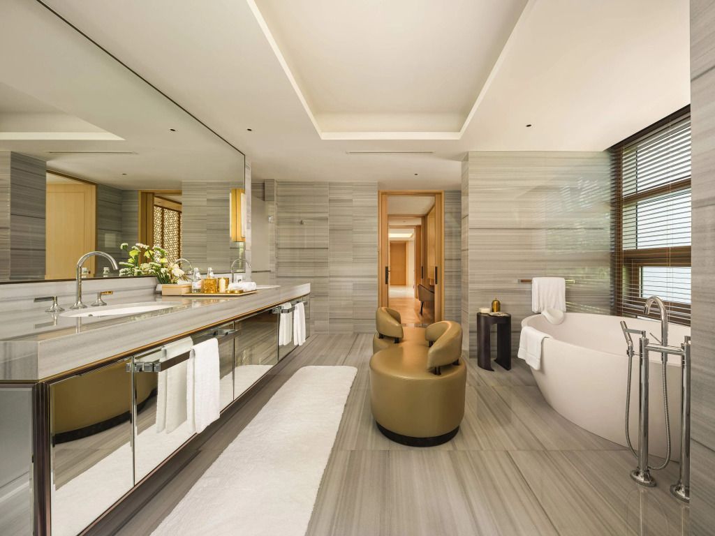 Modernes Badezimmer mit freistehender Badewanne und geräumigem Waschtisch in der Präsidenten Villa
