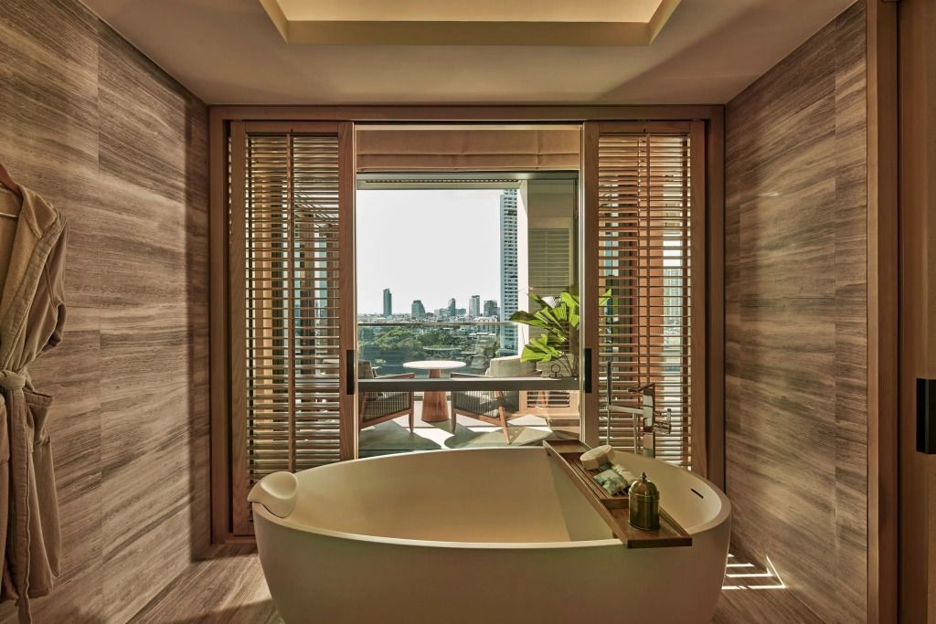 Badezimmer mit Badewanne und Balkonblick über Bangkok