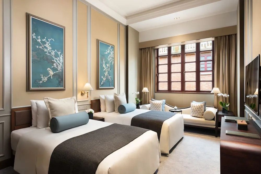 Zweibettzimmer mit stilvoller Wanddekoration und großen Fenstern