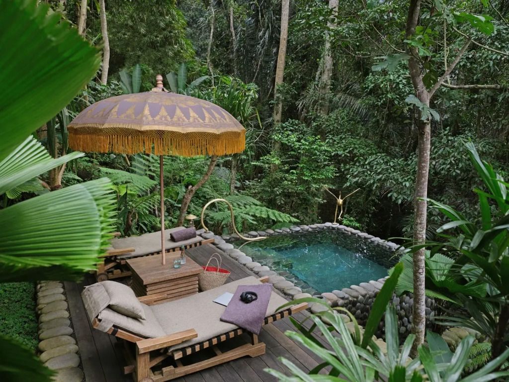 Private Terrasse mit Liegen neben einem kleinen, von Dschungel umgebenen Pool.