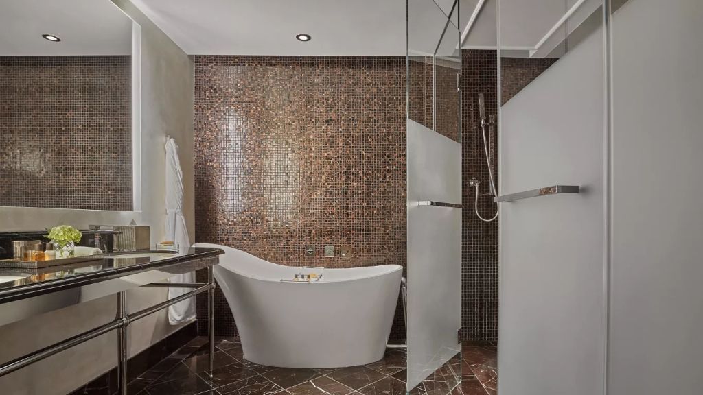 Modernes Badezimmer mit freistehender Badewanne und glitzernder Mosaikwand.