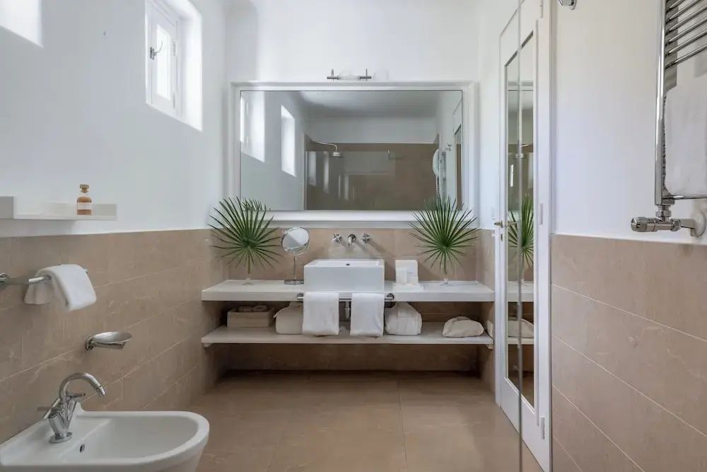 Modernes Badezimmer mit großen Spiegeln und minimalistischer Einrichtung