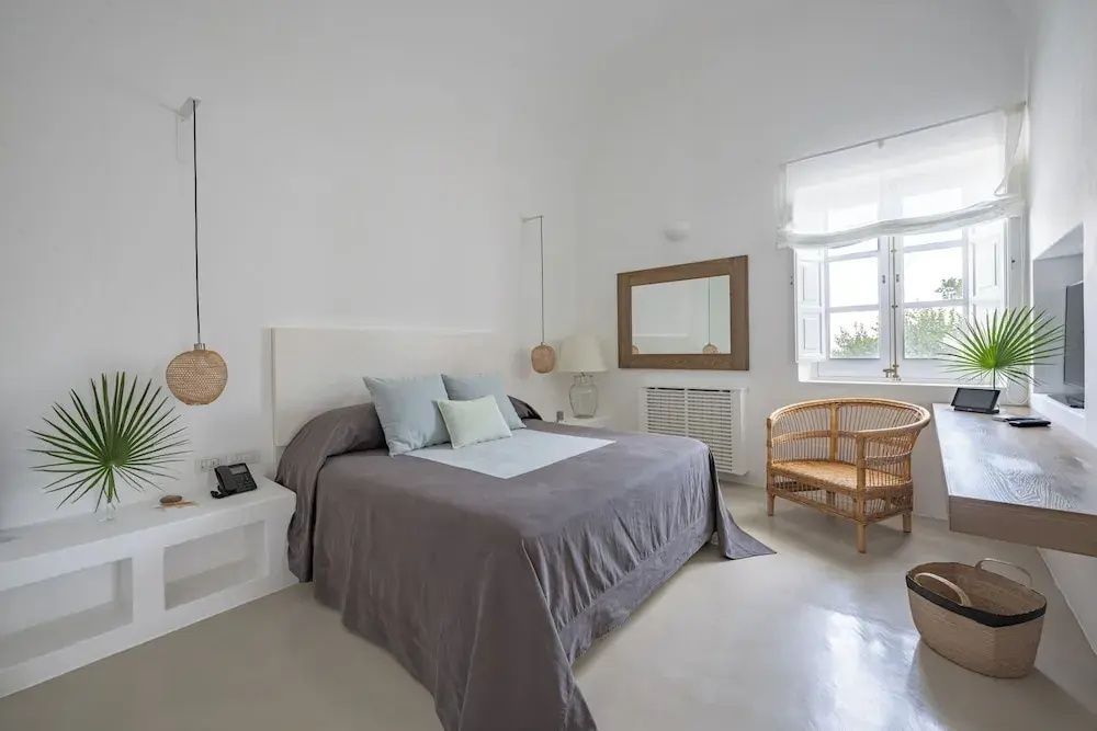 Helles Schlafzimmer mit großen Fenstern und stilvollen Möbeln