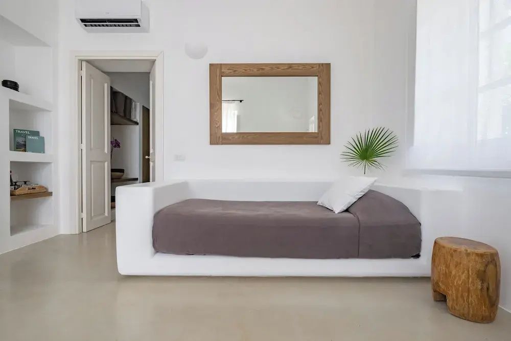 Modernes, minimalistisches Zimmer mit bequemer Couch und Spiegel