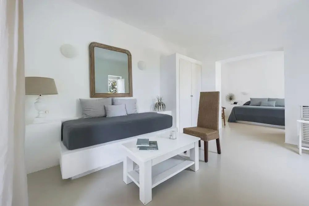 Moderner Wohnbereich mit Spiegel und grauem Sofa in einer Suite